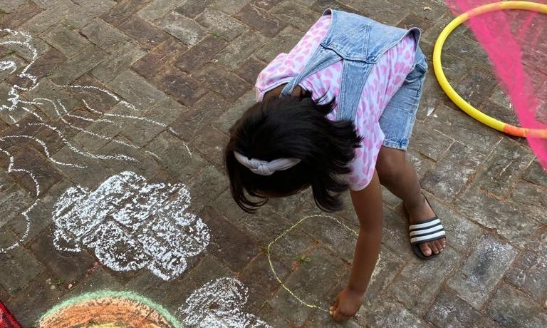 Child drawing on the courtyard floor