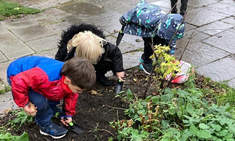 A child and caregiver gardening